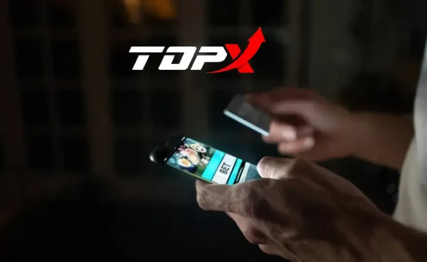 Imagem de marca da TopX: mãos usando um celular e um cartão sobre fundo escuro